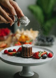 woman adding powder on sweet dessert