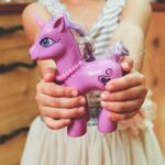 child holding unicorn toy