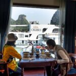 asian traveler with anonymous girlfriend having lunch on yacht