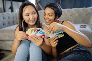 two women playing uno cards